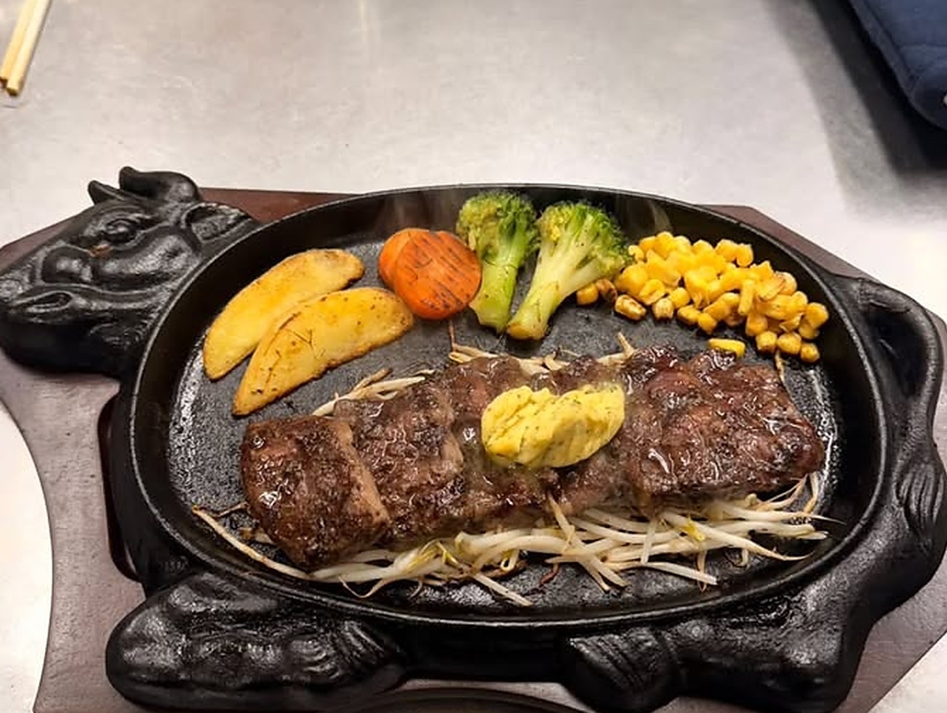 牛型鉄板に盛り付けたステーキの提供写真